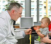 Prof. Dr. Hagen Thieme (l.) bei der Untersuchung eines Kleinkindes.